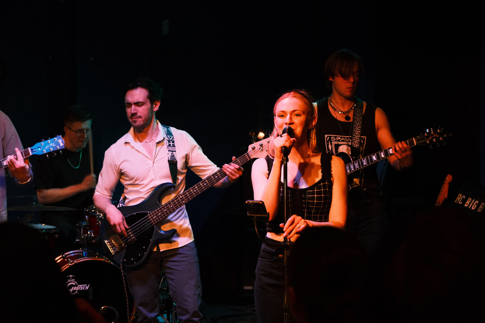 Midwest Honey's singer at the mic, flanked by bass and guitar