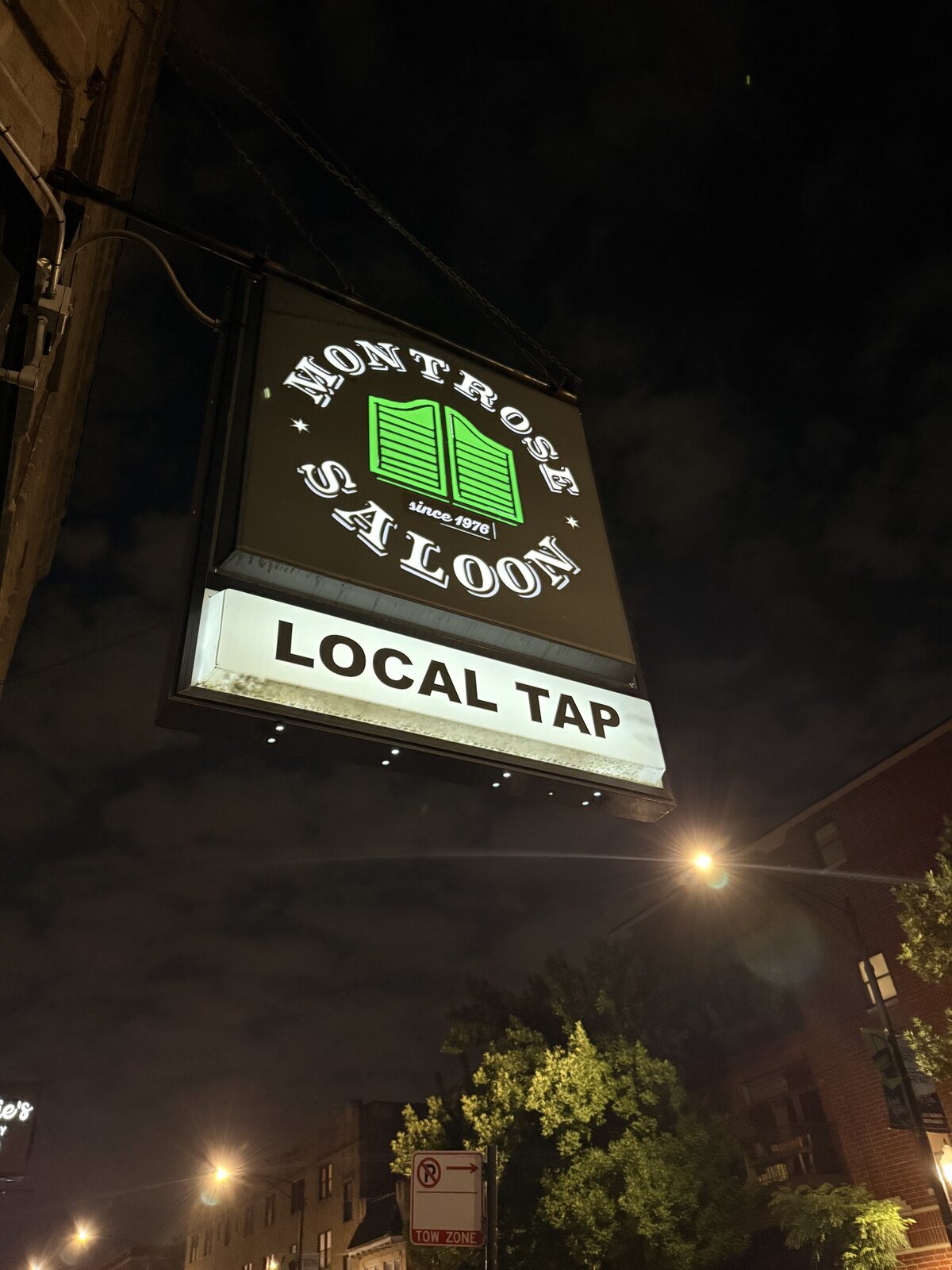 The Montrose Saloon sign lit up at night